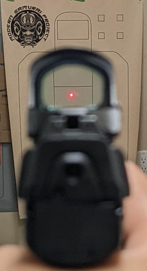 pistol red dot pointed at a clear target