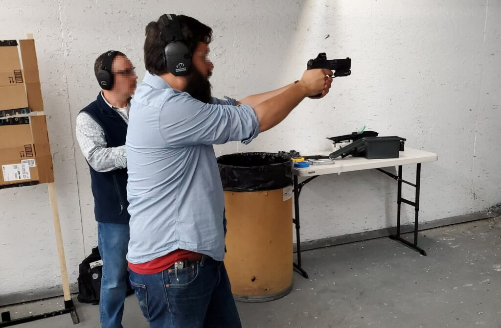 man firing a red dot pistol