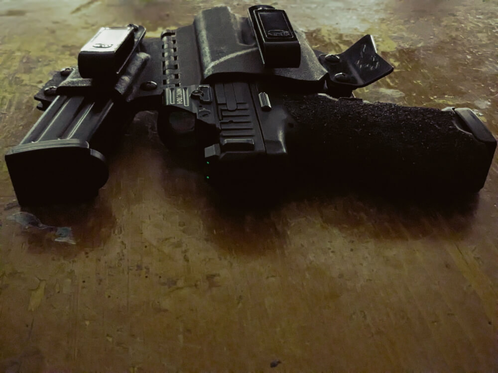 holstered VP9 laying on a wooden table with light shining